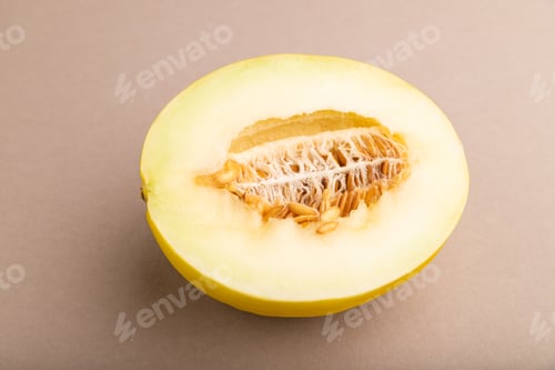 Preview: Sliced ripe yellow melon on brown pastel background. Side view, close up.