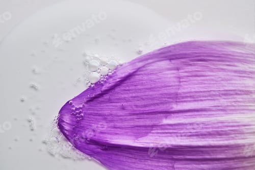 Preview: A drop of serum on a purple flower petal.