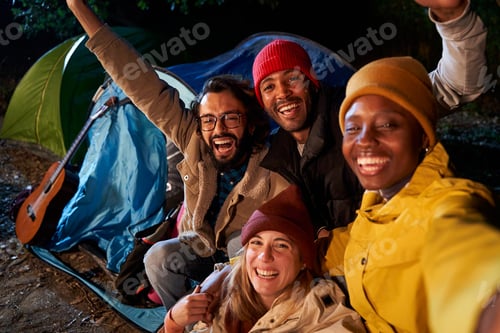 Preview: Happy selfie of a multiethnic group of friends doing camping in the mountain at night, having fun.