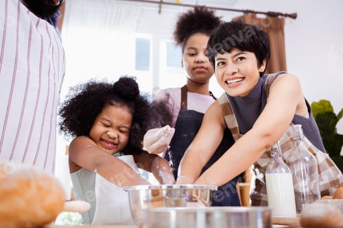 Preview: African American family help prepare the flour for making cookies
