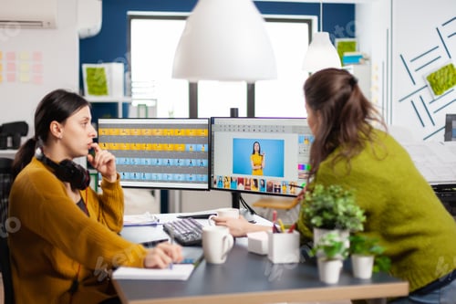 Preview: Confident women photo editors sitting at workplace in creative studio