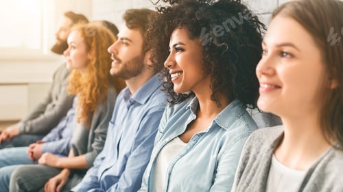 Preview: Diverse millennial group sitting in row, waiting for something