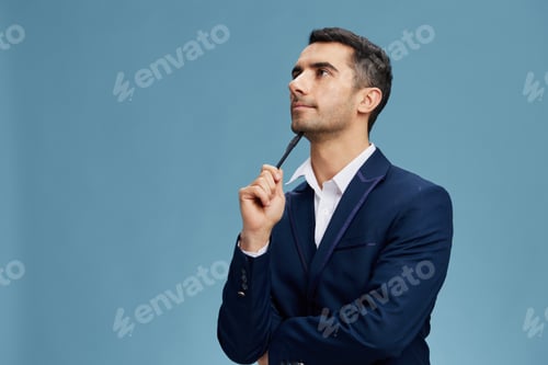 Preview: businessman portrait looking up business idea pen in hand in a stylish suit blue background