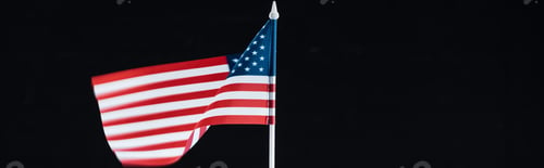 Preview: panoramic shot of national american flag on stick isolated on black with copy space