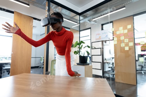 Preview: Woman using VR headset in modern office, interacting with virtual environment