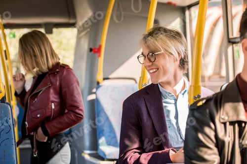 Preview: smiling young man in eyeglasses looking away in city bus