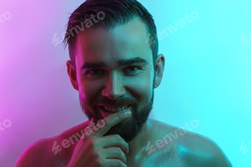 Preview: Handsome young man with wet skin in neon light