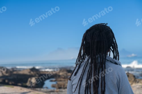 Preview: Woman seen sitting and looking at ocean