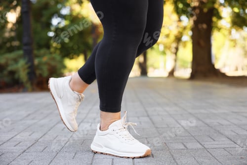 Preview: Woman in sneakers running outdoors, closeup. Healthy lifestyle