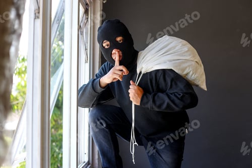 Preview: Thief carrying a large bag of loot over his shoulder trying to escape by the window