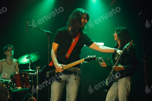 Preview: Guitarist and bassist performing on stage with green lighting