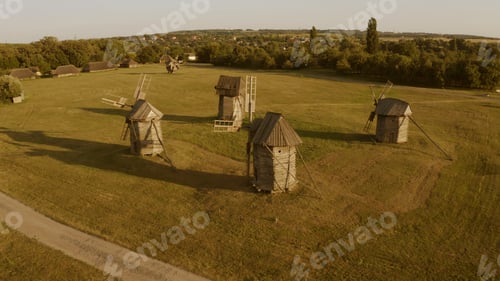Preview: Four wooden windmills in big meadow.
