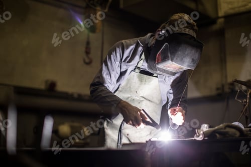Preview: Welder wearing welding mask welding