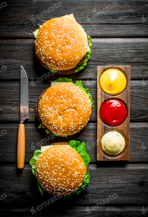 Preview: Burgers with different sauces and a knife.