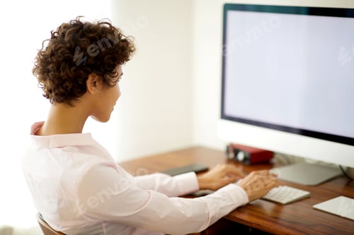 Preview: young business woman sitting by computer in office