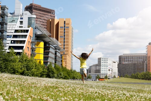 Preview: Germany, Berlin, happy young woman running on a meadow near Potsdam Square