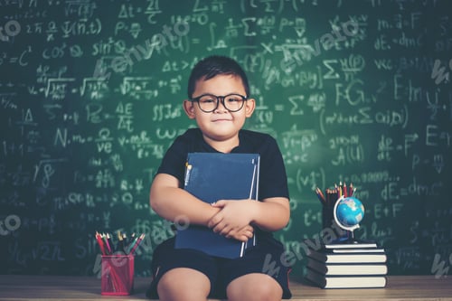 Preview: boy with books sitting near green chalkboard