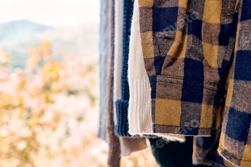 Preview: Knitted sweaters on hangers on the clothes rack. Slow Fashion. Conscious consumption. Garage sale.