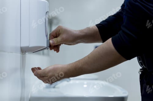Preview: Closeup shot of male hands being disinfected to avoid covid19