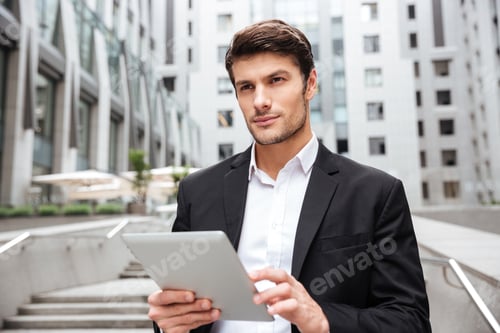 Preview: Pensive businessman using tablet in the city