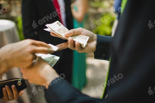 Preview: Man paying money bills to a woman in euros
