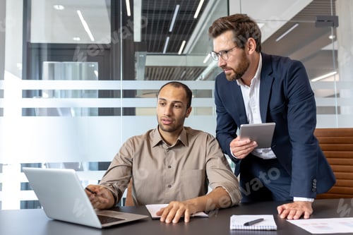 Preview: Two men in a modern office environment working together on a project