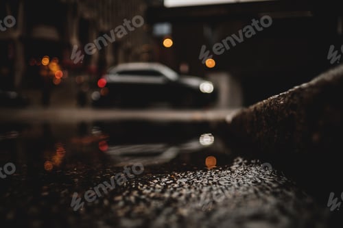 Preview: A low angle shot of a car with reflection in the puddle of water