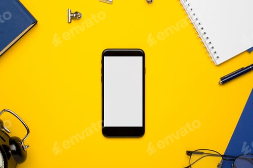 Preview: Mobile phone with white notepad , blue notebook and pen on yellow background
