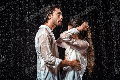 Preview: side view of couple in white shirts standing under rain isolated on black