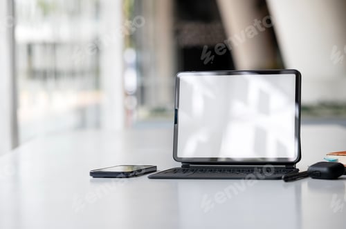 Preview: Digital talbet with keyboard, mock up blank white screen on the table.