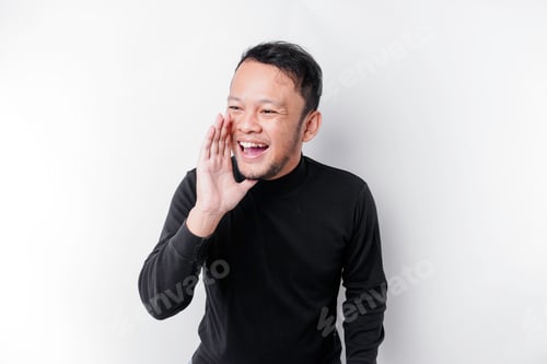 Preview: Young handsome man wearing a black shirt shouting and screaming loud with a hand on his mouth.