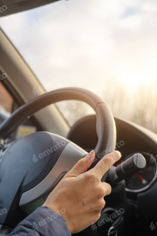 Preview: Lady hand holding steering wheel of car while driving.