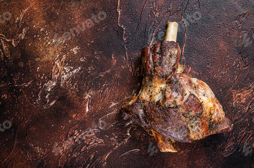 Preview: Roast Lamb leg with herbs and garlic. Dark background. Top view. Copy space
