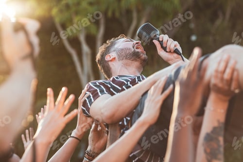 Preview: Crowd, surfing and man singing at party, outdoor music festival or social gathering. Microphone, en