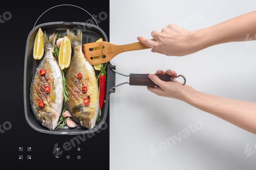 Preview: cropped shot of person cooking delicious fish with rosemary and cherry tomatoes on electric stove