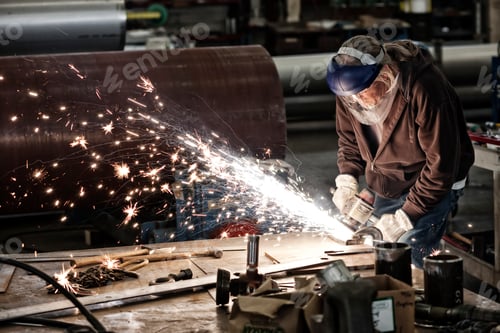 Preview: Factory worker grinding a steel edge in a sheet metal factory.