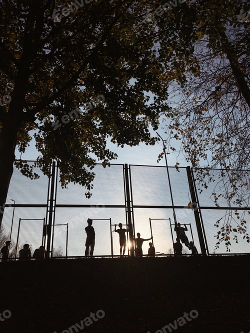 Preview: Light and shadows. People or kids are doing sports during sunset. Spots activities. Sunny light
