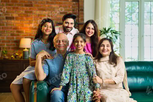 Preview: Closeup of Indian family of six sitting together on a sofa in a lavish home, joyful moments