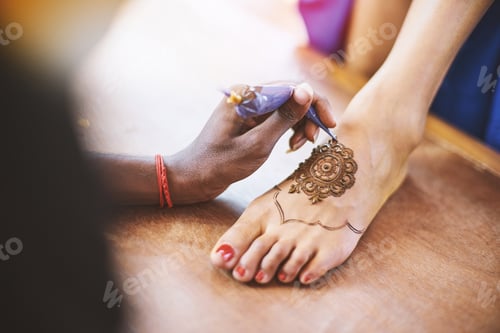 Preview: The Indian henna artist drawing the tattoo art (Mehndi) on the women foot on the indian wedding day