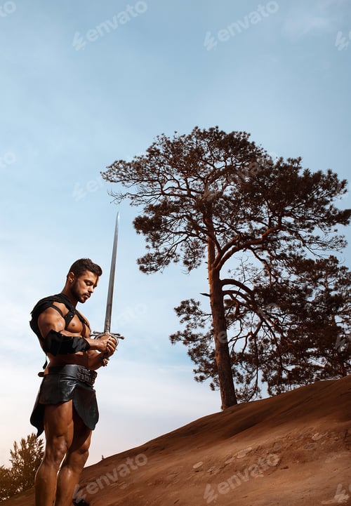 Preview: Young muscular warrior with a sword at the mountains