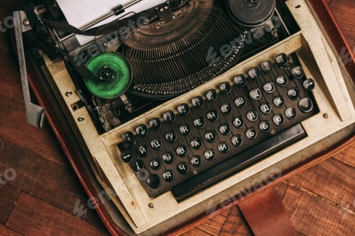 Preview: vintage typewriter with keys on a wooden background and a white sheet of paper