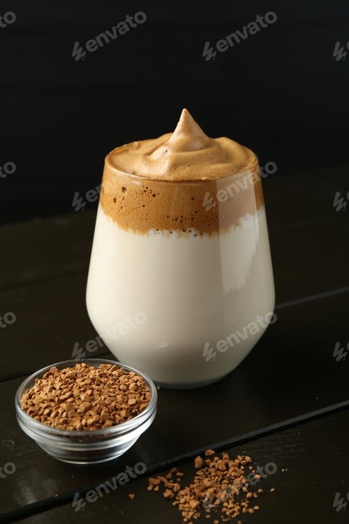 Preview: Delicious dalgona coffee in glass and granules on wooden table, closeup