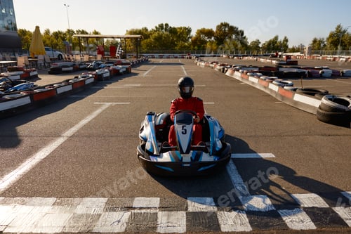 Preview: Competitive man racing in go-carts at finish of motor race track