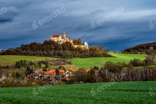 Preview: Majestic old castle situated atop a lush green hill, with a rolling expanse of grass in front