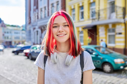 Preview: Fashionable beautiful girl teenager in wireless headphones with bright dyed colored hairstyle