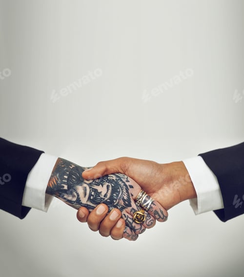 Preview: Inked agreement. Two businesspeople shaking hands, one with tattoos.