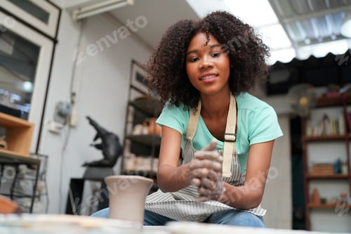 Preview: Young Woman hand potter making clay vase in pottery workshop, Business owner.