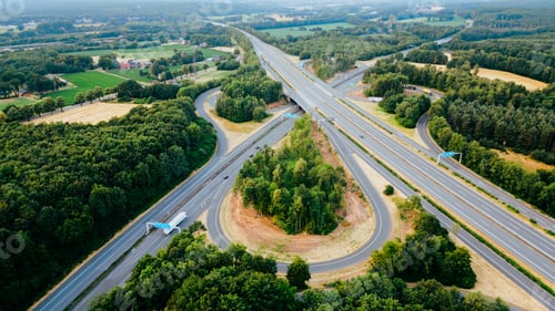Preview: Aerial view of German highway autobahn . Drone shot of highway among forest and green field.