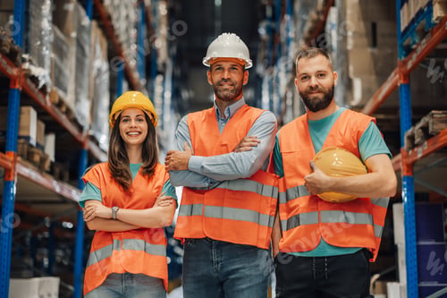 Preview: Warehouse workers posing with arms crossed wearing reflective vests and hard hats
