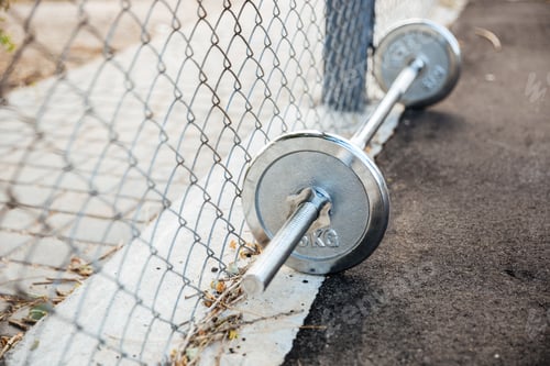Preview: Dumbbells with weights lying on sports ground